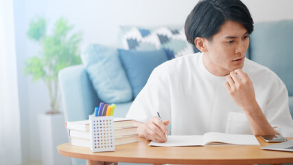 ノートパソコンでオンライン授業を受ける男性