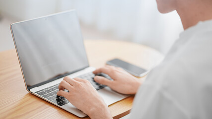 悩みながらノートパソコンを使う男性