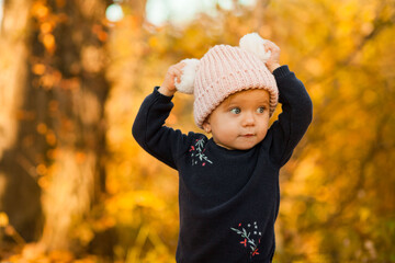 Bright autumn portrait of a cute baby on a walk. Orange.