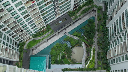 Aerial people in decorative garden outside apartment blocks