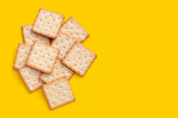 Dry cracker cookies on yellow background.
