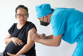 doctor giving vaccine injection to pregnant woman