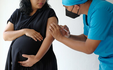 doctor giving vaccine injection to pregnant woman