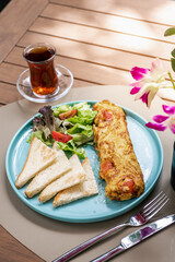 Delicious brunch platter made by eggs omelet, toasts and salad on the side