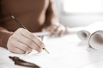 Architect working on blueprint. Architects workplace - architectural project, blueprints, ruler, calculator, laptop and divider compass. Construction concept. Blue print is fake only for stock photo.