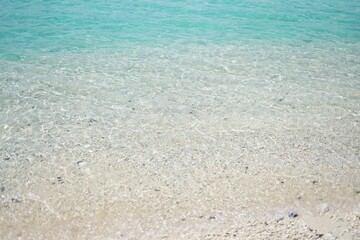 Fototapeta na wymiar 浅瀬の美しい白い砂浜のクローズアップ