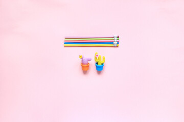 Items for drawing on a pink background. Layout from the sketching kit. Notepad, eraser and pencils on a pink background. View from above