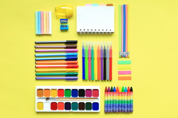 Painting supplies on a colored background. Set of first grader on a yellow background. Office...