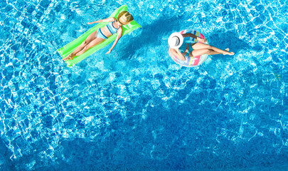 Children in swimming pool aerial drone view from above, happy kids swim on inflatable ring donut...