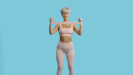 Beautiful sportive woman doing exercises with rubber bands. COPY SPACE