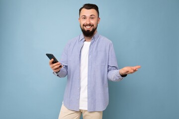 handsome young brunette unshaven man with beard wearing stylish white t-shirt and blue shirt...