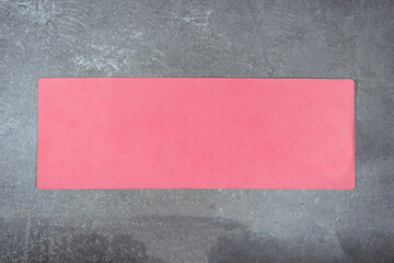Pink yoga mat on the concrete floor. The fitness mat is spread out on a cement floor. View from...