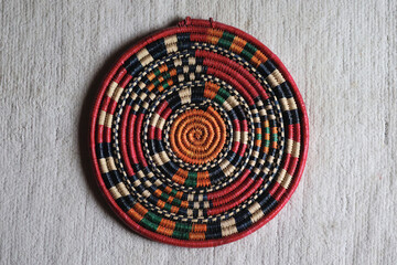 Top view of a woven mat from Uganda, made in traditional African basket weaving style, against a...