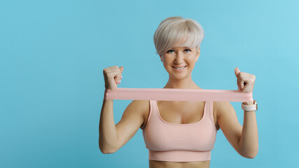 Beautiful sportive woman doing exercises with rubber bands. COPY SPACE