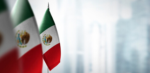 Small flags of Mexico on a blurry background of the city