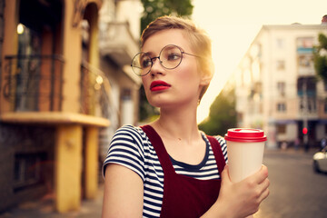 pretty woman with glasses on the street walk a cup of coffee