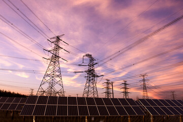 Transmission towers and solar panels are clean energy concepts. Sunset background