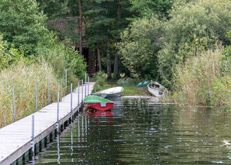the wooden footbridge on the lake shore, fishing boats