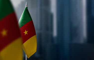 Small flags of Cameroon on a blurry background of the city