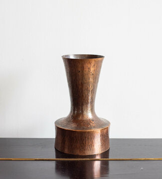 Mid-century modern copper vase - isolated on a black cabinet