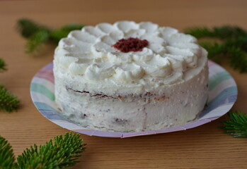 White cake on table with fir branches