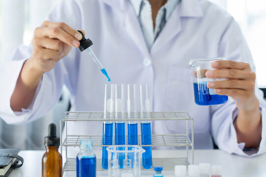 Scientist wear lab coat and protective wear are working with research or doing investigations with test tubes in experiment, Laboratory and development concept
