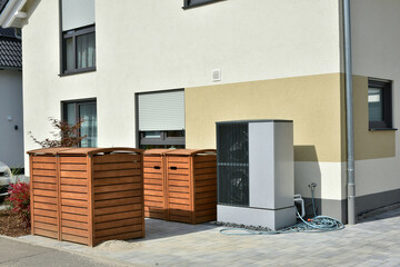 Luftwärmepumpe/Klimaanlage für Heizung und Warmwasser vor einem neu gebauten Wohnhaus