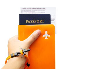 Covid-19 vaccination record card and passport in hand