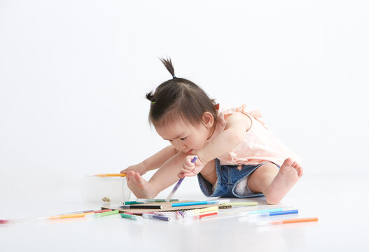 Cute Asian little girl painting indoors