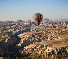 colorful balloon  in the flight in Cappadocia,  in front of Uchisar rock houses
