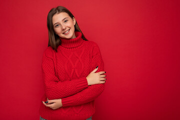 Obraz premium Young smiling beautiful brunette woman with sincere emotions isolated on background wall with copy space wearing casual red sweater. Positive concept