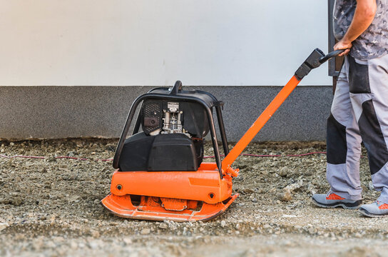 A Man Holds Vibrating Rammer Machine