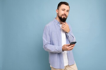 handsome young brunette unshaven man with beard wearing stylish white t-shirt and blue shirt...