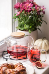 Autumn breakfast. Rooibos tea cup, pastry and pumpkin on the windowsill. Cozy home