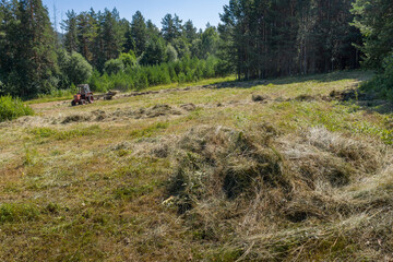 Southern Urals. Mountain meadow. Tractor on the hayfield. Aerial view.