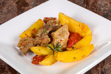 Baked pork meat with potao and tomato