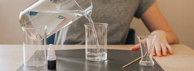 Teenage girl filling a glass with water. Banner.