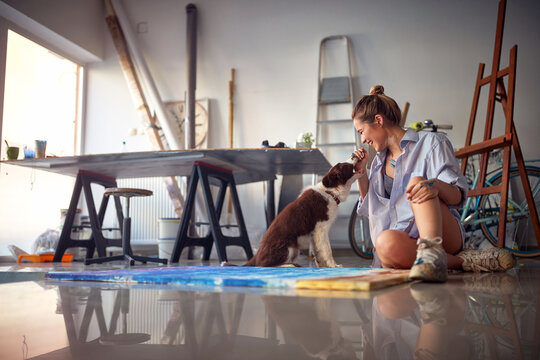 Young hot female artist playing with her dog
