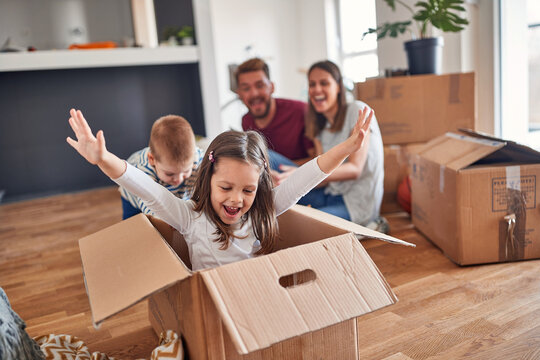 A young family is playing in the new home they have just moved in. Home, family, moving