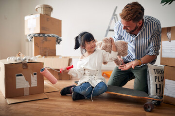 Happy  japanese girl playing with her father , having fun while moving home