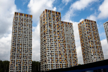 Fototapeta premium blue sky with clouds through the beautiful geometry of residential high-rise buildings 