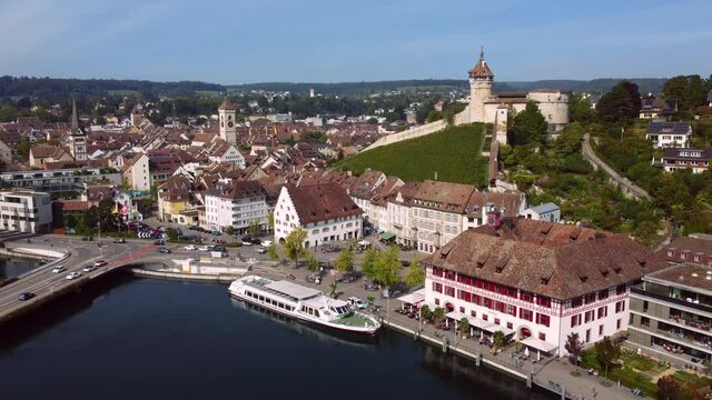 Aerial drone footage of the Schaffhausen old town by the Rhine river on a sunny summer day in eastern Switzerland with the famous Munot medieval fortress. 