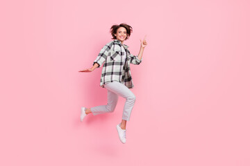 Fototapeta na wymiar Full size photo of funny millennial brunette lady jump point wear shirt trousers isolated on pink background