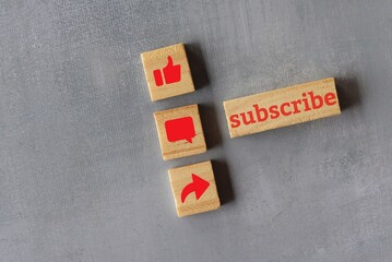 Technology and media social concept. Top view of wooden cubes with text SUBSCRIBE and like, comment...
