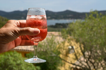 Un verre de rosé avec des glaçons en main