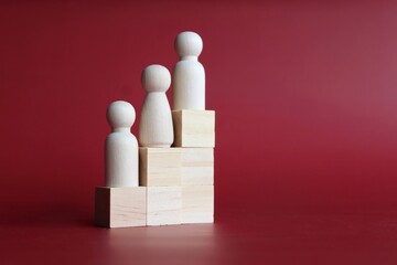 Selective focus image of wooden doll stand on staircase ladder with copy space. Growth, success and leadership concept