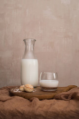 Milk in a glass and a bottle on a wooden board close up