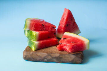 Several slices of fresh watermelon on a blue background