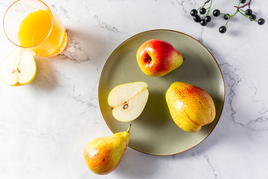 Overhead Shot Of Fresh Pears On A Plate With Fresh Juice On White Background.