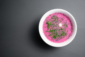 cold beetroot soup with cucumber, boiled egg, dill and yogurt in white bowl